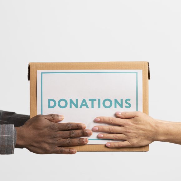 volunteer giving box with donations another volunteer 580x580